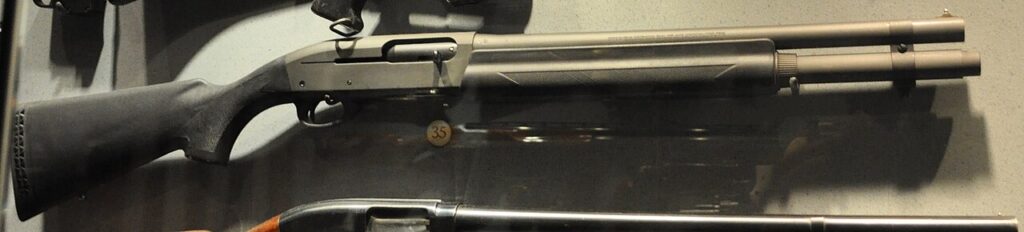 A black Remington 11-87 shotgun displayed horizontally against a plain background.