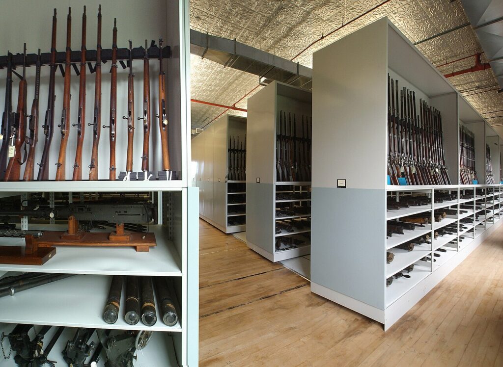 Rows of historic rifles stored on metal shelving inside the Springfield Armory National Historic Site archives.